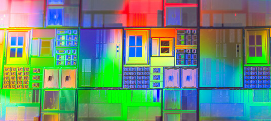 silicon wafer with microchips reflecting different colors.