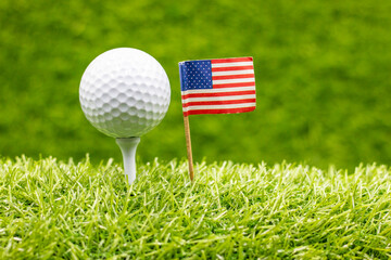 Golf ball with flag of America on green grass background