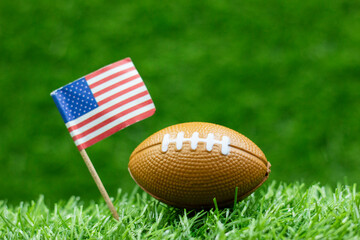 American football with American flag are on green grass