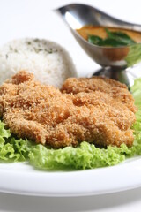 crispy deep fried chicken chop fish cutlet serve with nyonya spicy curry sauce and steam fragrant white jasmine rice and lettuce