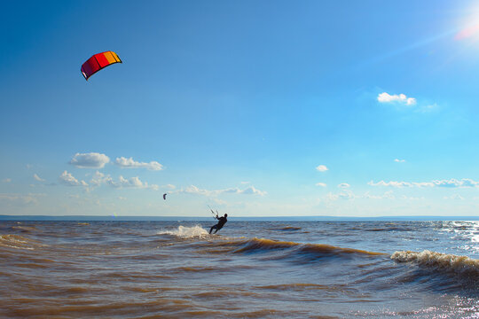 Kiteboarder surfing waves with kiteboard on a sunny summer day.