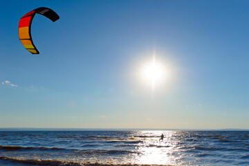 Kiteboarder surfing waves with kiteboard on a sunny summer day.