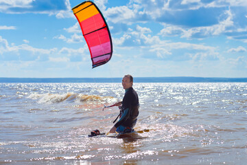 Kiteboarder surfing waves with kiteboard on a sunny summer day.