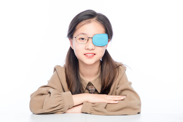 Little Asian girl with amblyopia on white background