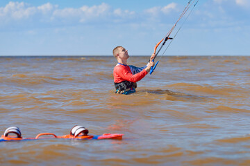 Kiteboarder surfing waves with kiteboard on a sunny summer day.