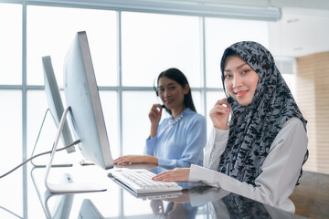 Muslin woman in call center team working in office and headset and computer for support customer service