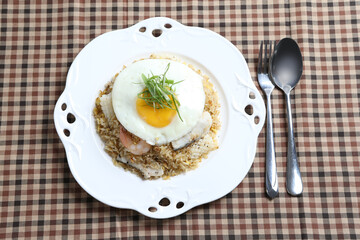 wok garlic fried rice with mixed seafood fish, prawn, squid, octopus, fried egg and vegetables on white plate asian halal menu