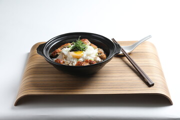 chef cook Hong Kong congee porridge with mixed seafood unagi, fish, prawn, squid, mushroom, egg and vegetables in black hot clay pot , chopstick spoon asian healthy halal menu