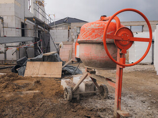 Red manual cement mixer in a construction site