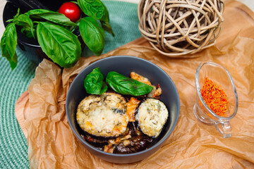 baked eggplant in cheese with spices, basil leaves and seasoned with saffron