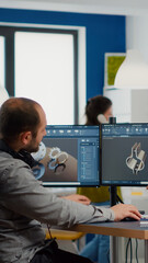 Diverse team of engineers working on computer at mechanical piece design cad sharing ideas about...