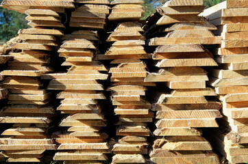 the boards are stacked after sawing. the ends of unedged boards