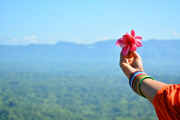 girl holding flowers over the sky