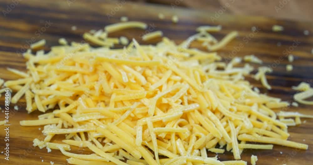 Sticker Grated cheese falling onto a cutting board slow motion
