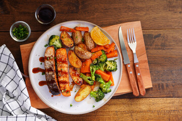 Homemade Grilled Salmon Steak with Broccoli, Potatoes, Carrots in a plate on a wooden table