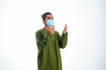 Covid19, the concept of health care and medicine. A young man pray in a face mask, supporting social distance