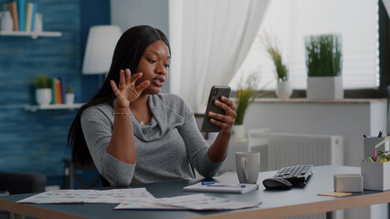 Black student chatting with math professor explaining online maths lesson using university platform sitting at desk in living room. African woman having online videocall meeting conference working