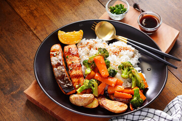 Homemade Grilled Salmon Steak with Broccoli, Potatoes, Carrots in a plate on a wooden table