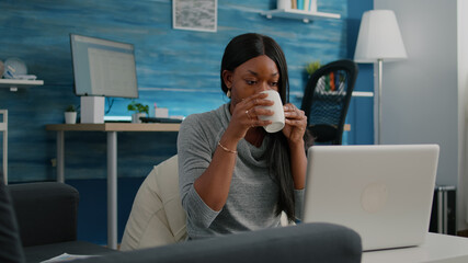 Black student smiling while working at social media blog article typing communication project...