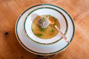 Leberknoedelsuppe, an Austrian Liver Dumpling Soup, a Beef Broth with Chives with Spoon