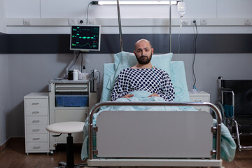 Potrait of depressed sick man lying in bed waiting for respiratory treatment recovering after...