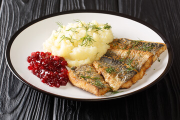 Swedish food Fried herring Stekt Stromming with Potato Puree closeup in the plate on the table. Horizontal