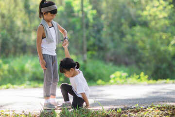 Cute asian girl give hand to help sister accident during running