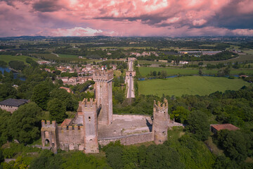 Obraz premium Aerial view of the Italian historic castle Castello Scaligero on sunrise, view of the Mincio river. Castle Scaligero in Valeggio sul Mincio, Italy. Aerial panorama of the Scaligero castle, Verona.