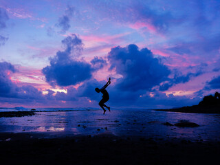 jumping on the beach in blue sunset