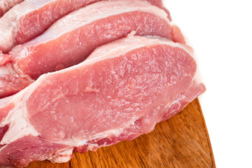 chopped into pieces raw pork on a wooden cutting board on a white background.