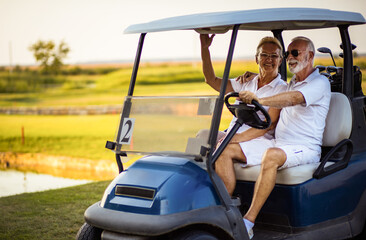 Fototapeta na wymiar Senior golf's couple in golf car.
