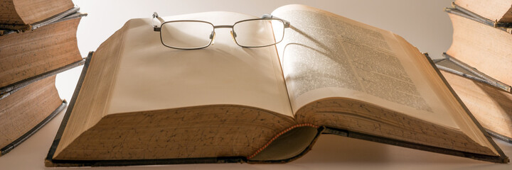 Antique book with glasses isolated. Panoramic image