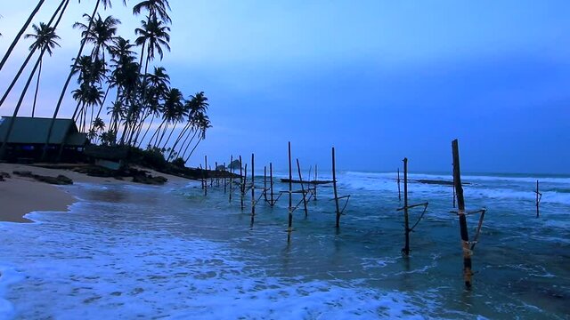 Koggala beach with fishing poles and wave