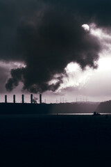 Power station on the coast at sunrise.  Global warming concept with colour toning