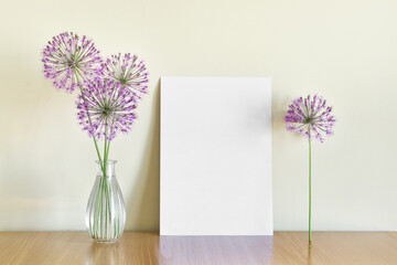Mockup template with A4 paper and summer flowers in glass vase on wooden shelf.