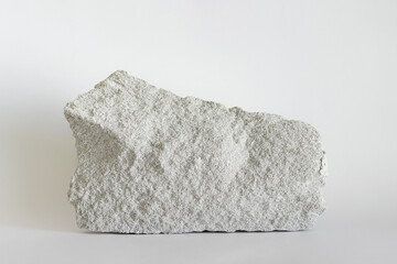 Large white building stone with visible porous surface on white background.