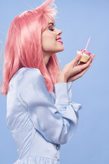 cheerful glamorous woman with pink hair cake in her hands