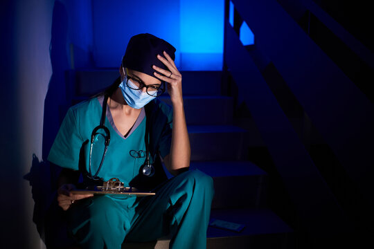 Thoughtful doctor reading documents in darkness