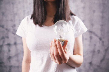 young woman holding a light bulb