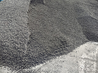 gravel on the dock ready to be loaded onto the ship. he tread of a large forklift truck on the...