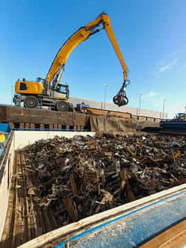 loading and unloading of scrap metal in the port/ Equipment in the port for loading and unloading operations for the disposal and recycling of scrap metal. Crane manipulator with gripper in the port f