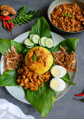 Traditional Malaysian Peranakan cuisine / Nasi Kunyit aka Turmeric Glutinous Rice / Delicious dish eaten with dry curry chicken with glutinous rice cooked in coconut milk and turmeric