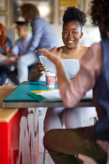 Obraz premium A young female employee is listening to her colleague while working in the office