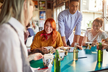 Group of young creative employees is enjoying a lunch break in the office