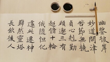 Practising Chinese calligraphy at home with brush and black ink