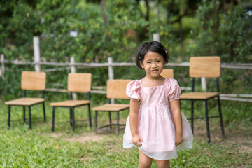 Smiling little Asian girl standing outdoor.