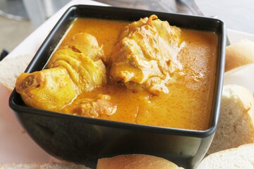 Curry chicken and potato, bread dipped into curry, the Indian cuisine