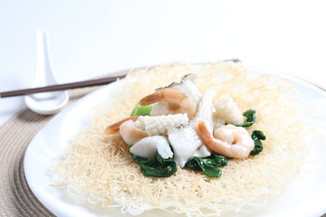 deep fried crispy bee hoon noodle with mixed seafood fish, prawn, squid, octopus and vegetables in thick egg gravy sauce asian halal menu