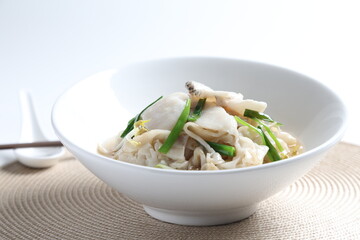 hot wok fried kway teow noodle with grouper fish slices and vegetables in thick gravy egg sauce in bowl asian halal menu