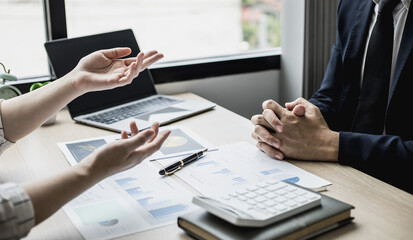 Two businessmen are brainstorming together and reviewing the company financial documents that the finance department has summarized, they are business partners. Business administration concept.